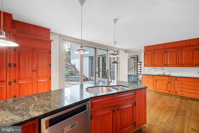 a kitchen with stainless steel appliances granite countertop a sink a stove and a wooden cabinets