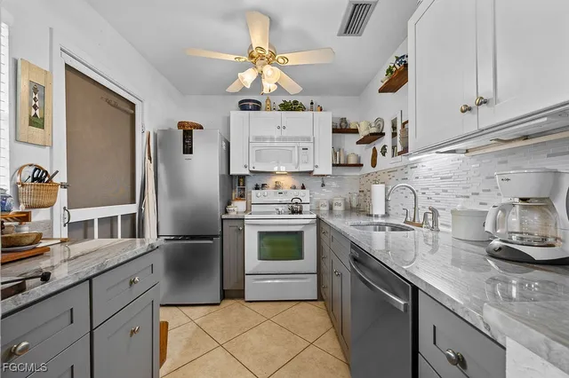 a kitchen with stainless steel appliances granite countertop a sink a stove and refrigerator