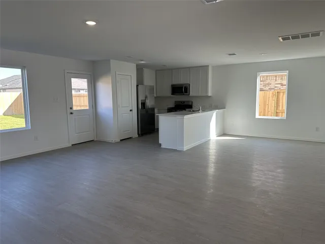 a view of a kitchen with furniture wooden floor and windows