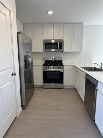 a kitchen with stainless steel appliances granite countertop a stove a refrigerator and a sink