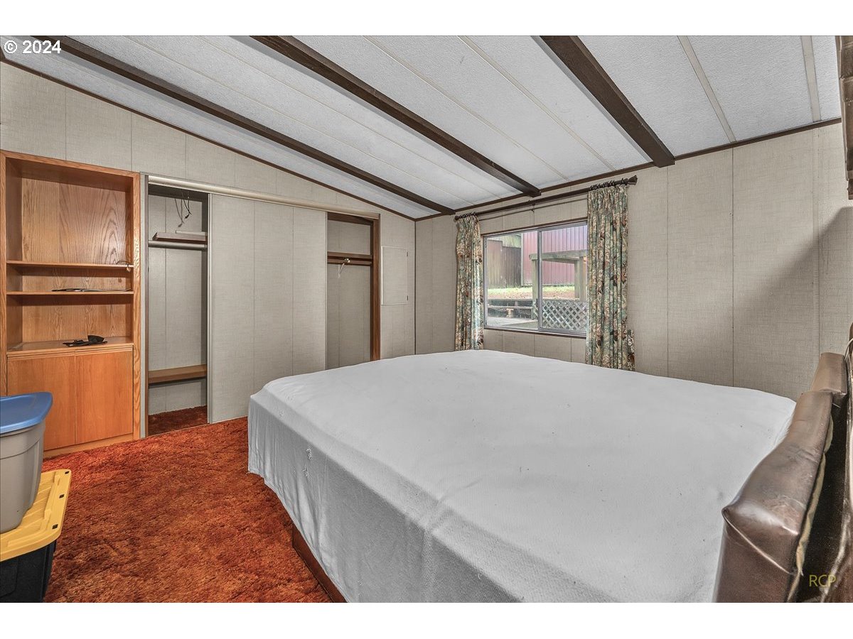 56925 Walker Road Scappoose, OR 97056 - Photo 15 of 40 a bedroom with a bed a dresser and a large mirror