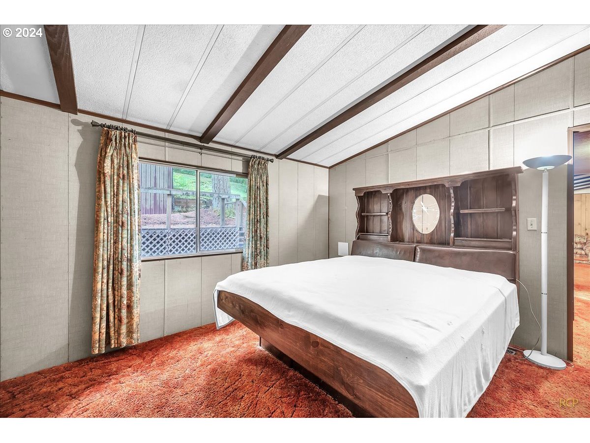 56925 Walker Road Scappoose, OR 97056 - Photo 16 of 40 a bed sitting in a bedroom next to a window