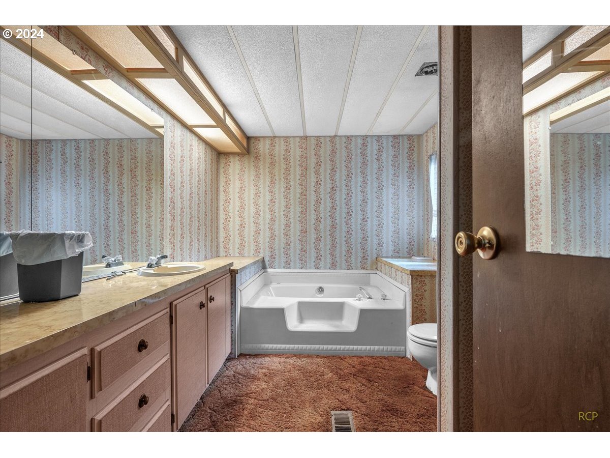 56925 Walker Road Scappoose, OR 97056 - Photo 17 of 40 a bathroom with a sink a mirror and a shower