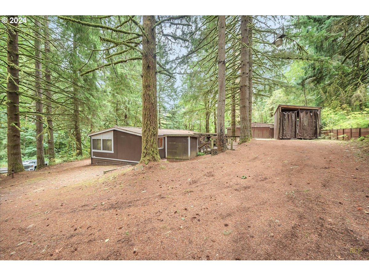 56925 Walker Road Scappoose, OR 97056 - Photo 25 of 40 a big house with large trees and wooden fence