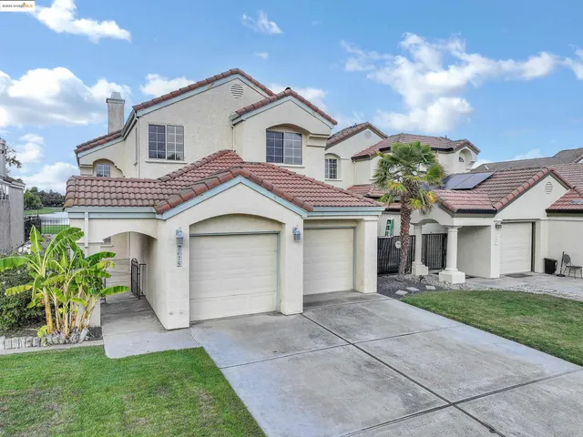 a front view of a house with a garden and plants