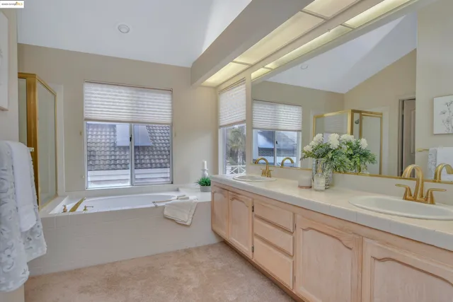 a bathroom with a granite countertop sink mirror bathtub and toilet