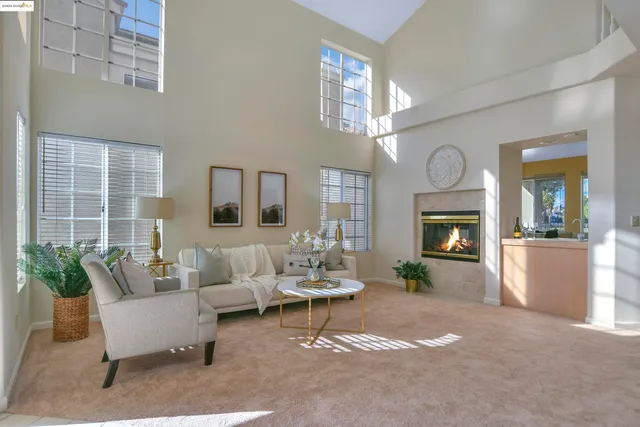 a living room with furniture a large window and a fireplace