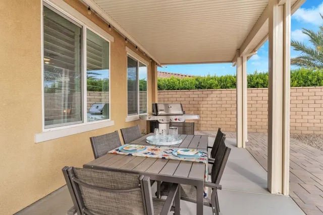 a dining room with furniture a rug and a floor to ceiling window