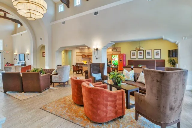 a view of a lake with a house and a yard with potted plants