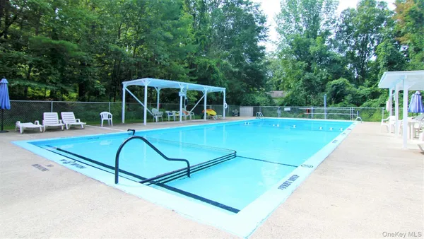 a view of backyard with swimming pool and outdoor seating