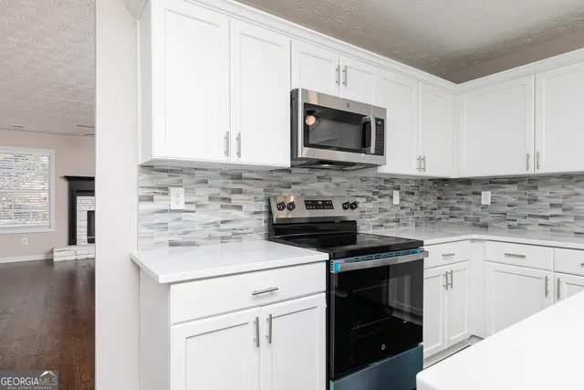 a kitchen with white cabinets and stainless steel appliances