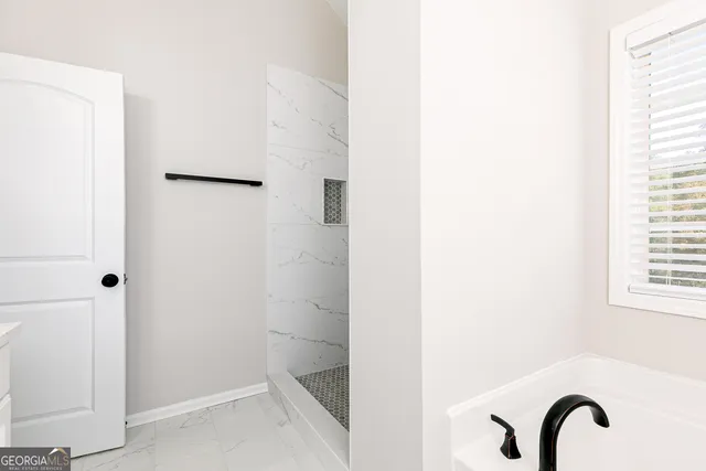 an empty room with chandelier fan and windows