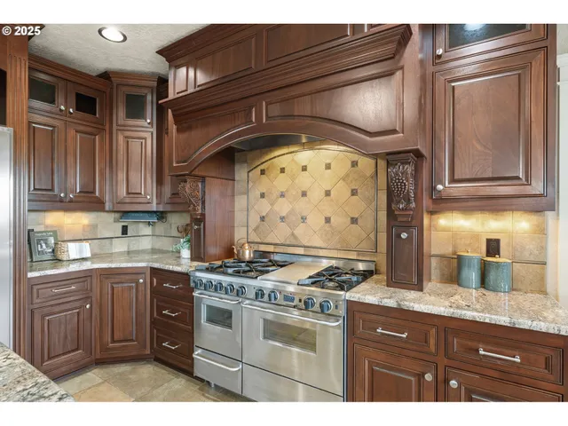 a kitchen with stainless steel appliances granite countertop a stove and cabinets