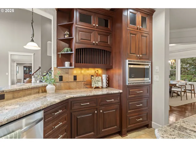 a kitchen with stainless steel appliances granite countertop a sink a stove and a wooden floors