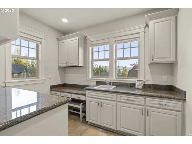 a utility room with granite countertop a sink a washer and dryer