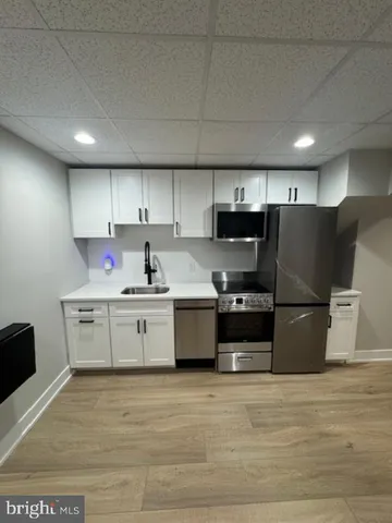 a kitchen with stainless steel appliances a refrigerator sink and cabinets