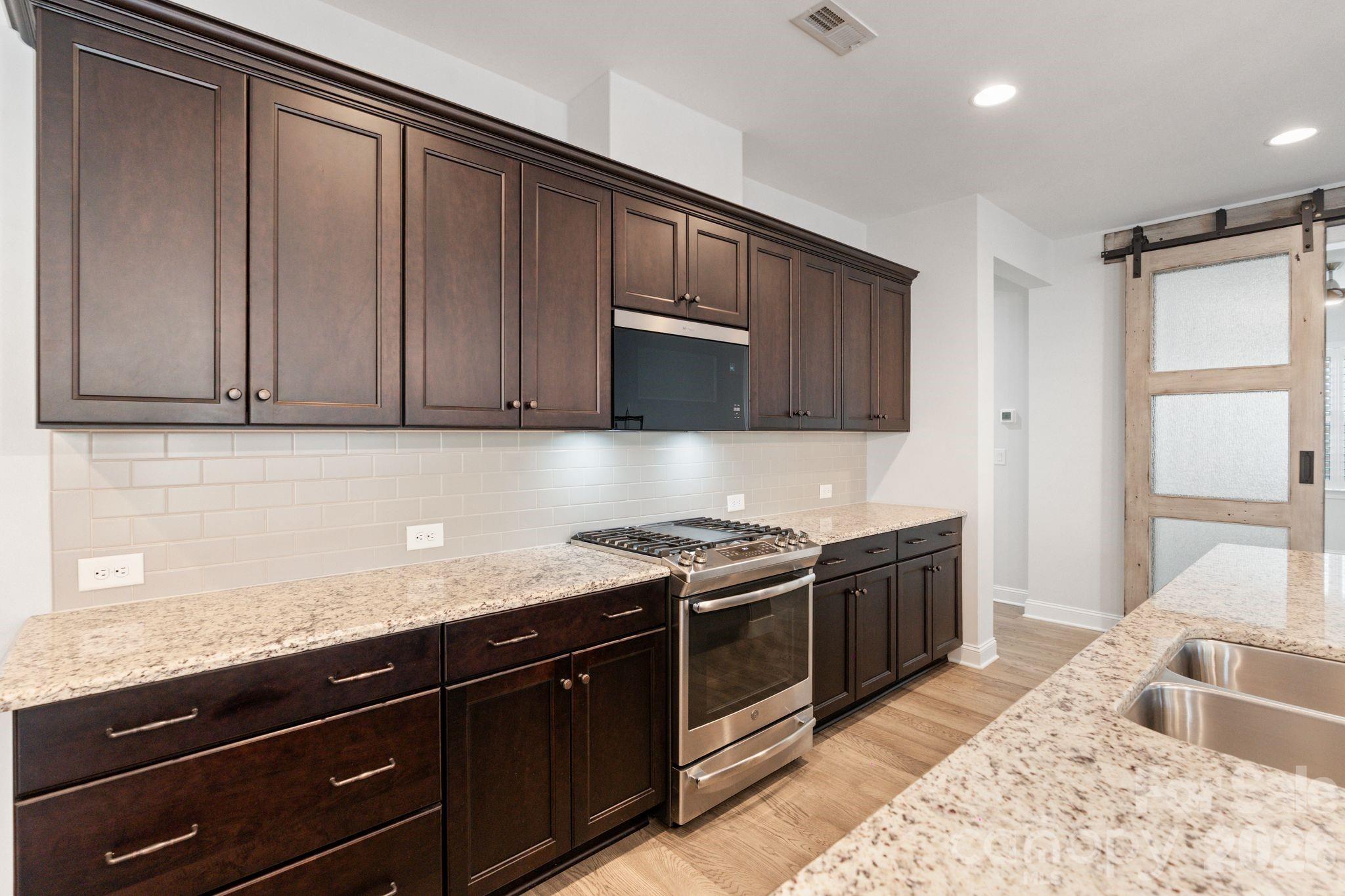 4995 Looking Glass Trail Denver, NC 28037 - Photo 15 of 46 a kitchen with stainless steel appliances granite countertop a sink stove and cabinets