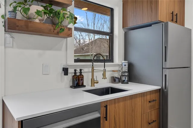 a kitchen with a sink a refrigerator and a stove