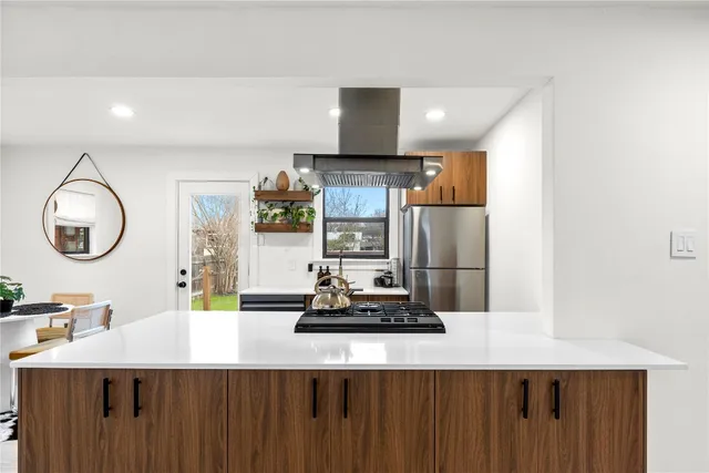 a kitchen with a refrigerator a sink and a wooden floor