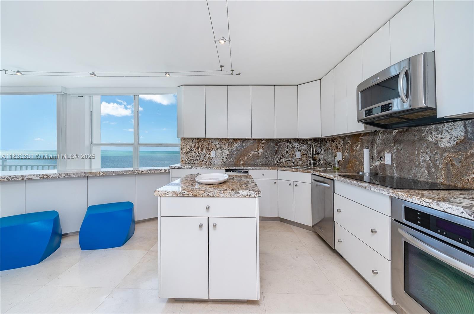 613 Ocean Drive, Unit 7C Key Biscayne, FL 33149 - Photo 12 of 42 a kitchen with stainless steel appliances granite countertop a sink and a stove