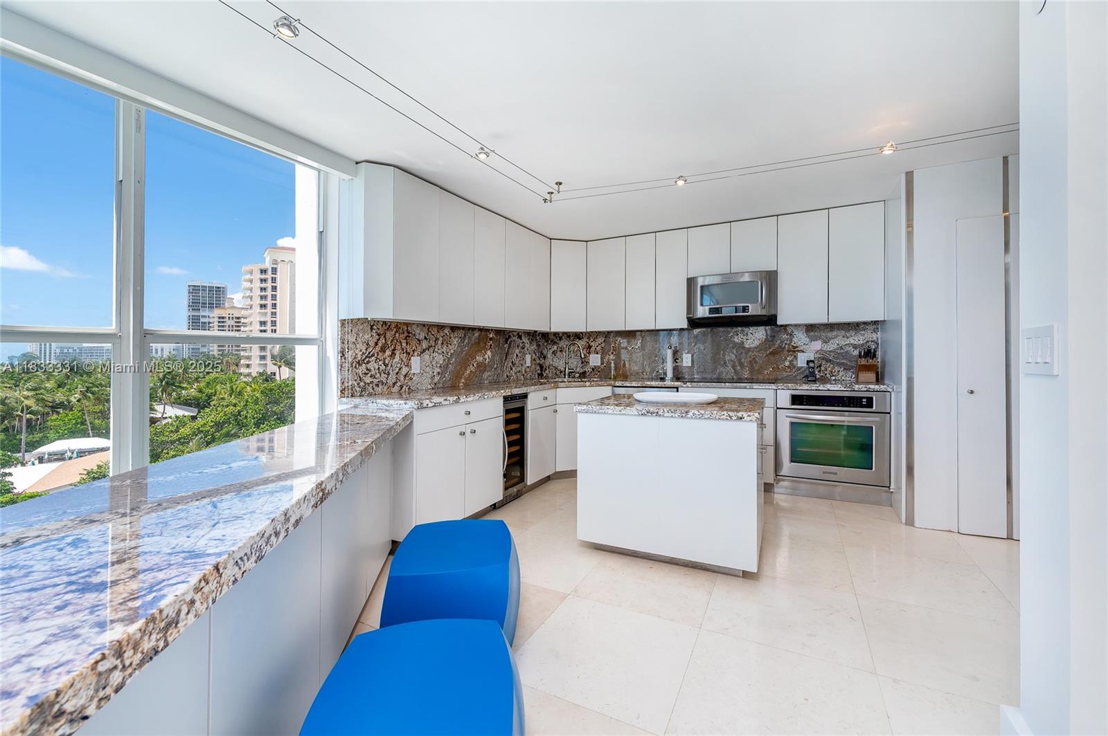 613 Ocean Drive, Unit 7C Key Biscayne, FL 33149 - Photo 14 of 42 a kitchen with white cabinets and white appliances