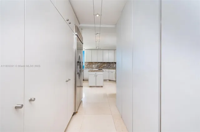 a view of a hallway with a refrigerator and a sink