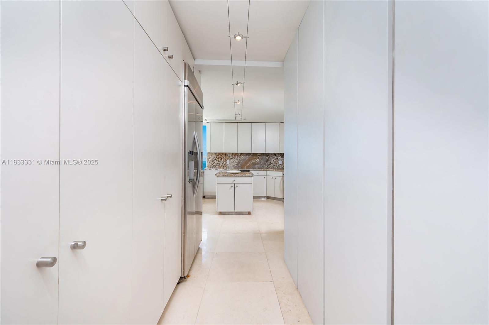 613 Ocean Drive, Unit 7C Key Biscayne, FL 33149 - Photo 17 of 42 a view of a hallway with a refrigerator and a sink