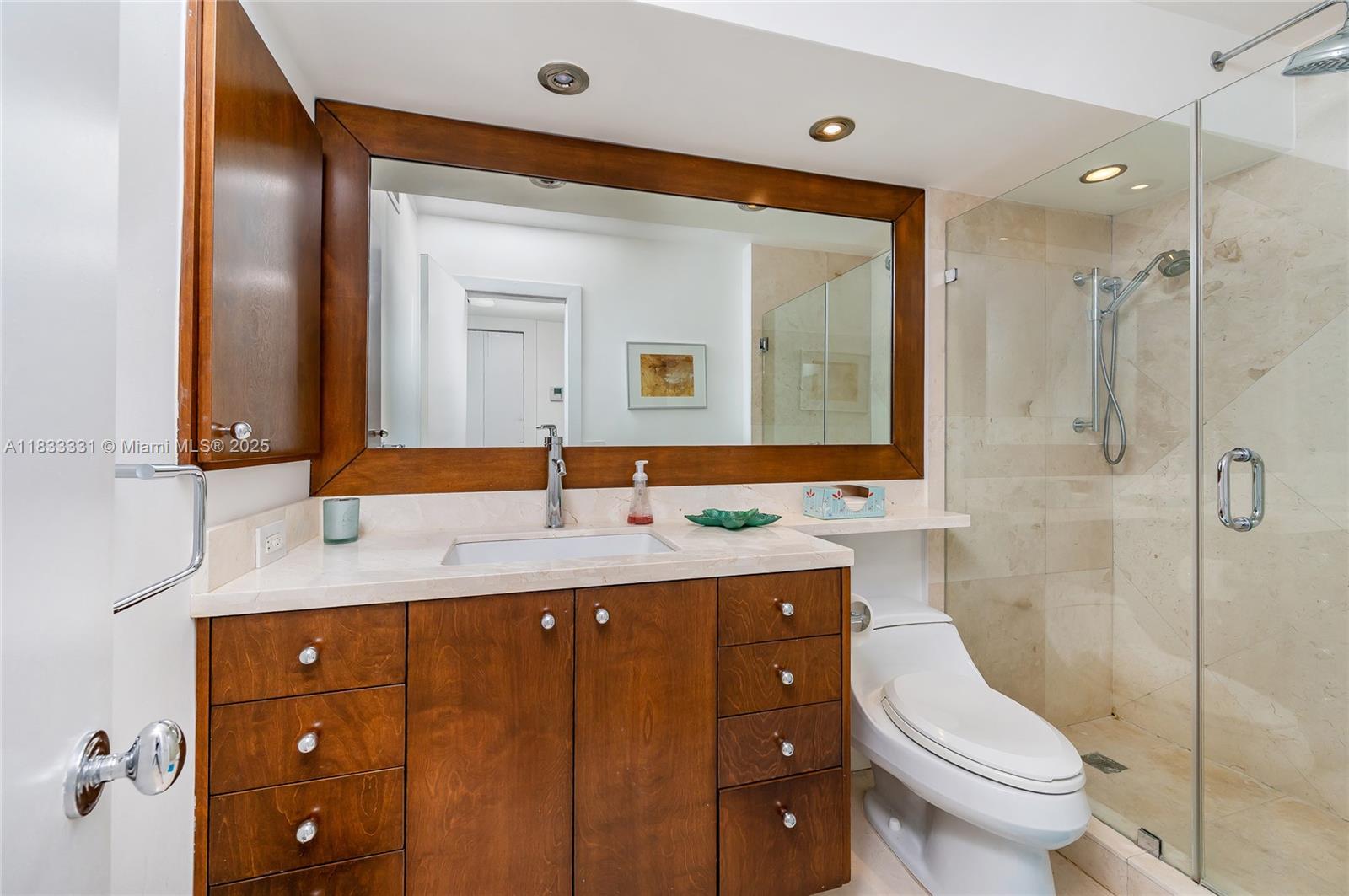 613 Ocean Drive, Unit 7C Key Biscayne, FL 33149 - Photo 22 of 42 a bathroom with a toilet sink and mirror