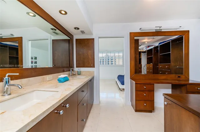 a kitchen with kitchen island granite countertop a sink and a refrigerator