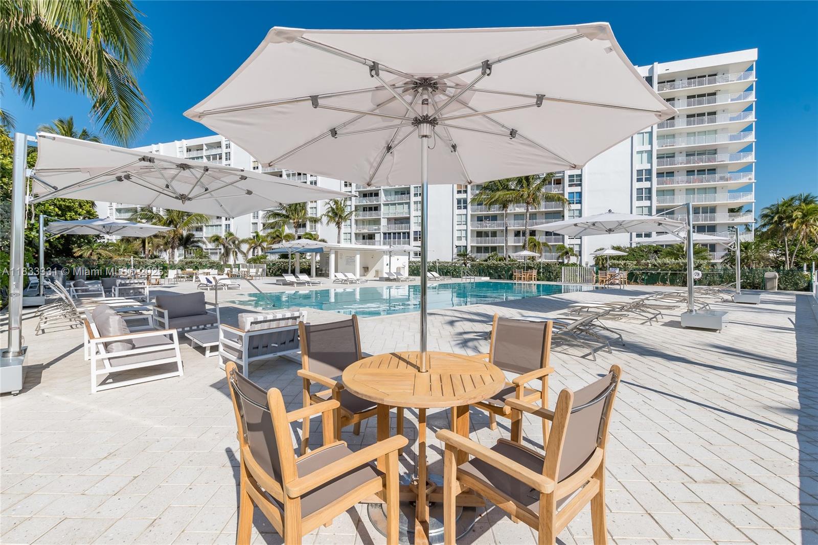 613 Ocean Drive, Unit 7C Key Biscayne, FL 33149 - Photo 31 of 42 a patio with a patio table and chairs