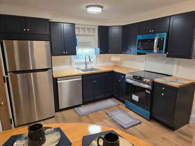 a kitchen with stainless steel appliances granite countertop a refrigerator and a stove