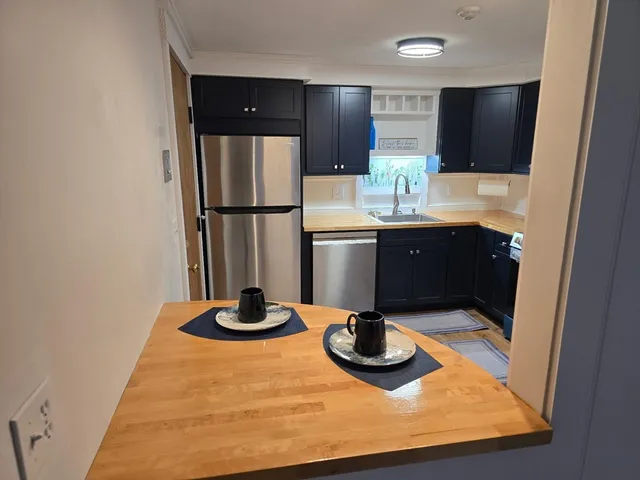 a kitchen with stainless steel appliances granite countertop a sink and a refrigerator