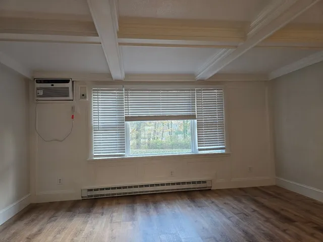 an empty room with wooden floor and a window