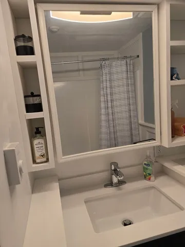 a bathroom with a sink a toilet and a mirror