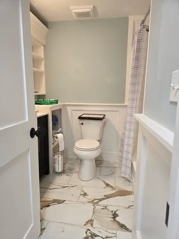 a bathroom with a toilet and a shower