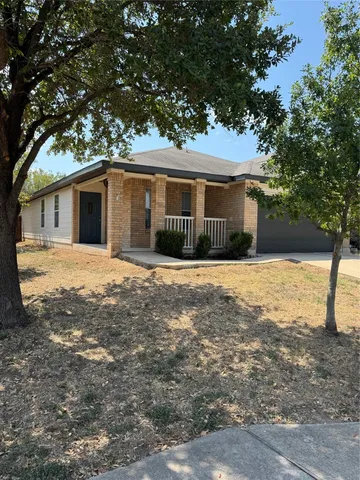 a front view of house with yard and trees around
