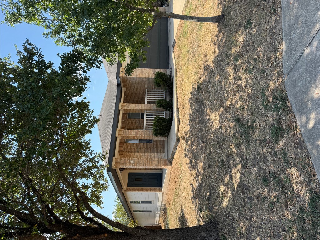 a front view of house with yard and trees around
