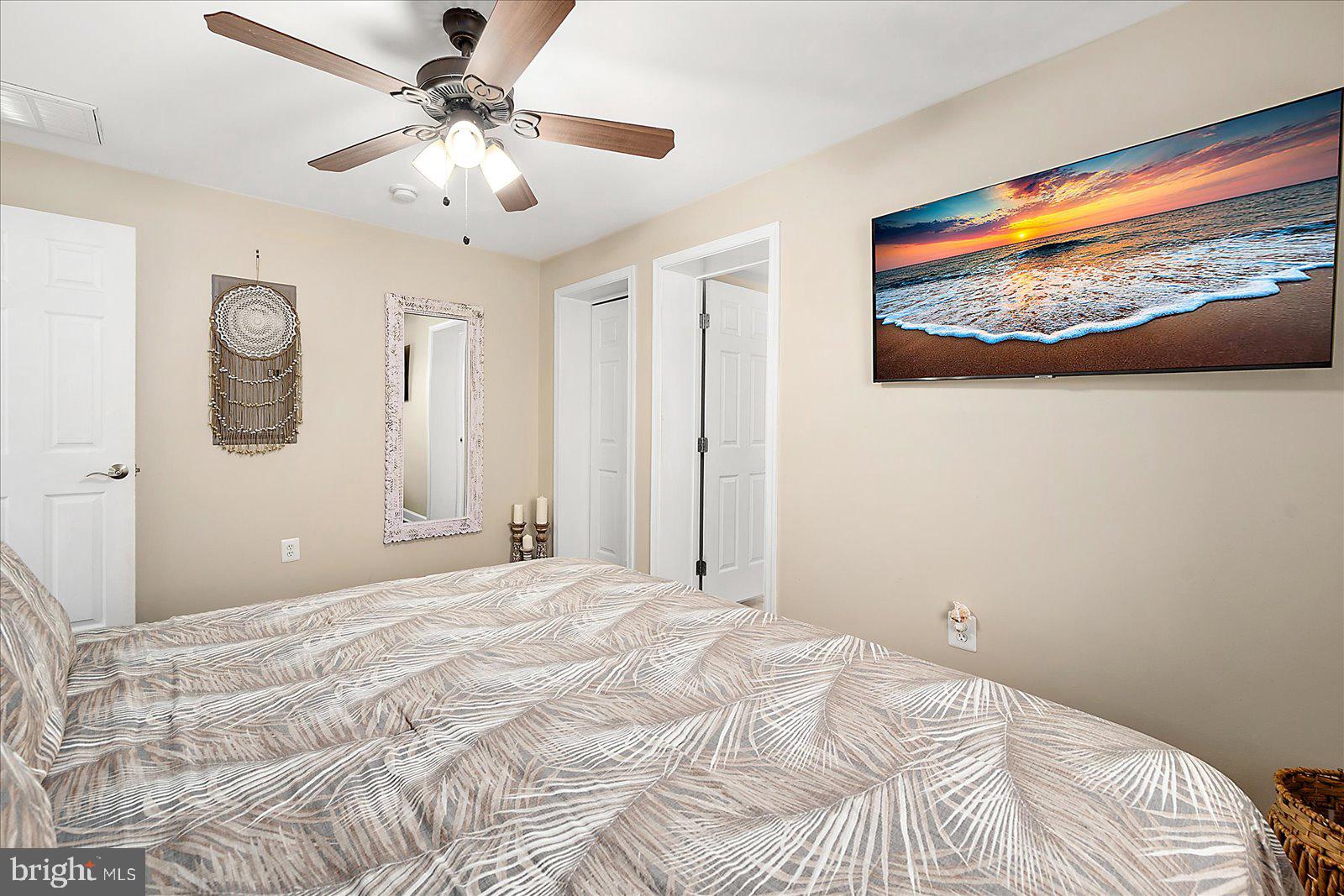 10428 Exeter Road Ocean City, MD 21842 - Photo 25 of 56 a bedroom with a large bed and a chandelier