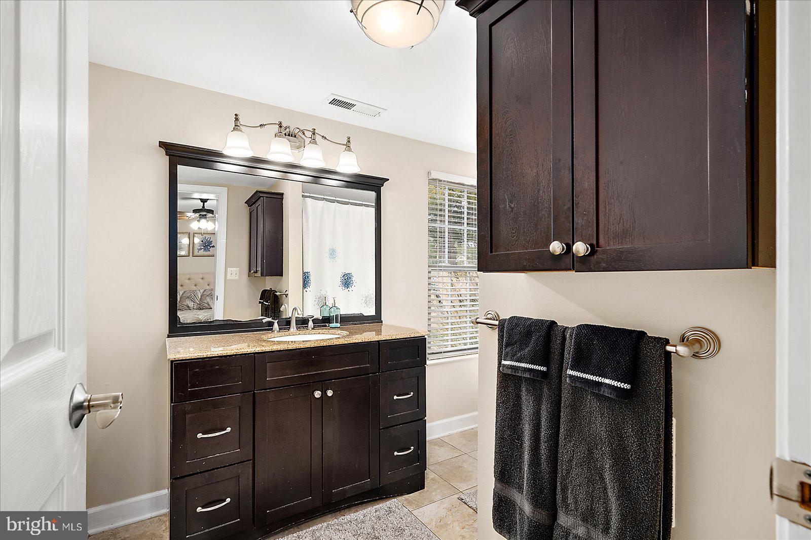 10428 Exeter Road Ocean City, MD 21842 - Photo 26 of 56 a bathroom with a double vanity sink and mirror