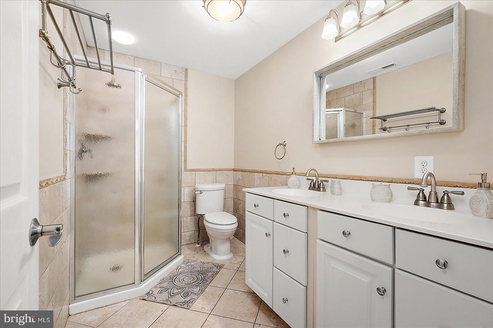 10428 Exeter Road Ocean City, MD 21842 - Photo 33 of 56 a bathroom with a granite countertop sink a mirror and a shower