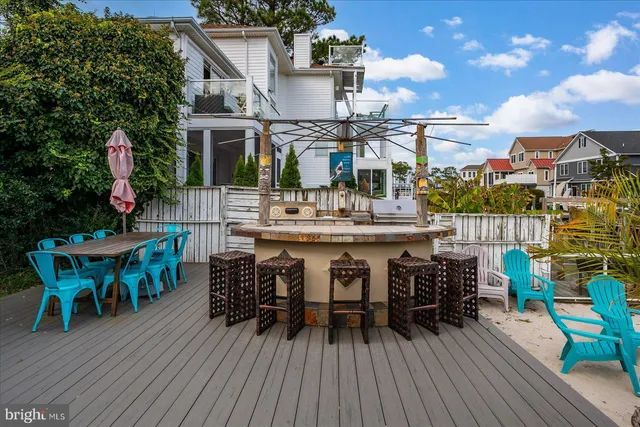 a view of a patio with dining table and chairs with wooden floor and fence