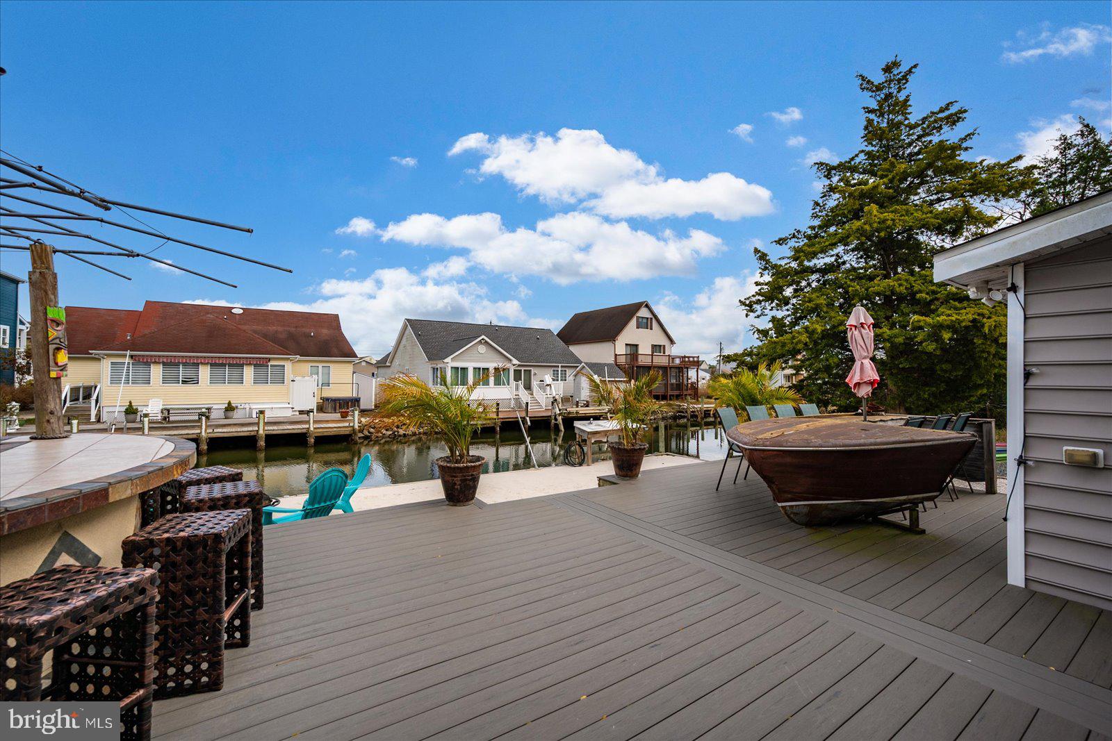 10428 Exeter Road Ocean City, MD 21842 - Photo 42 of 56 a view of a patio with dining table and chairs with wooden floor and fence