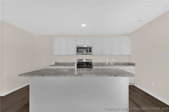 a kitchen with granite countertop a stove and a sink