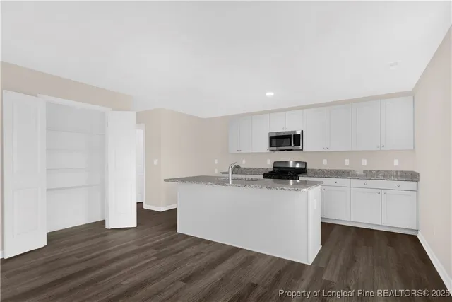 a kitchen with granite countertop a sink and a stove top oven