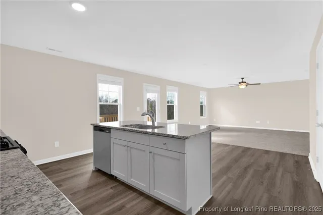 a kitchen with granite countertop a sink and cabinets