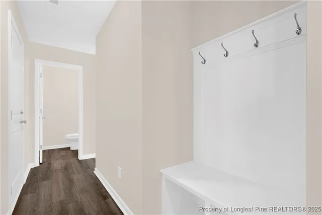 a view of a hallway with wooden floor and closet