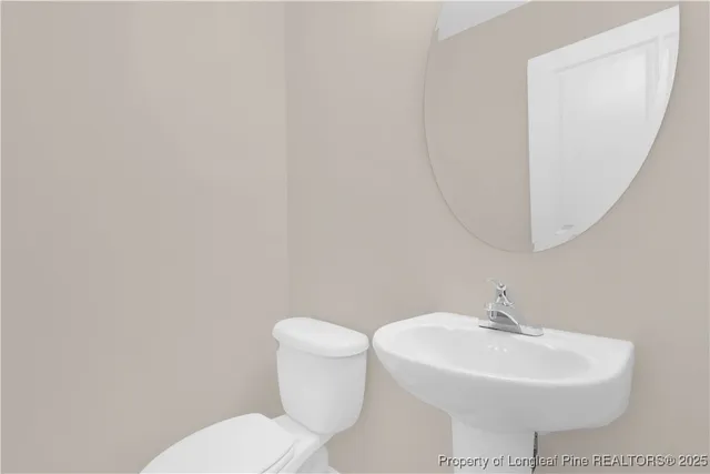 a bathroom with a sink a toilet and mirror