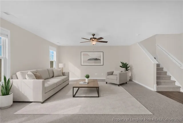 a living room with furniture and a potted plant