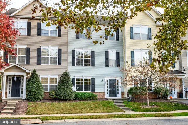 a front view of a house with a yard and trees