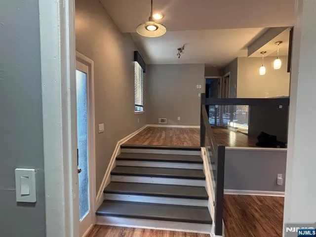 a view of entryway and hall with wooden floor
